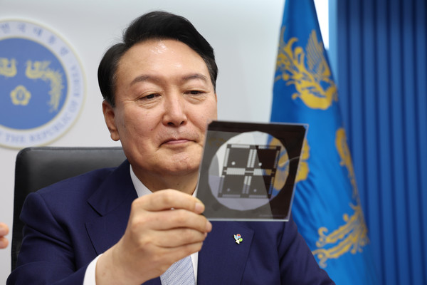 尹锡悦总统为打造“K-芯片”品牌，正致力于集中培养芯片产业。但至于加入“CHIP4”联盟，韩国尽管承认与美国合作的必要性，但同时也在考虑此举可能会引发中方的反对，因此目前韩国仍在持有慎重态度。图为，今年6月在龙山总统室大楼影像会议室举行的国务会议上，尹锡悦总统正在观察芯片。 【照片来源：韩总统室】