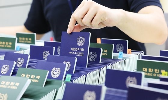 随着海外旅行需求的增加，护照发放数量也在随之增加。图为7月7日，京畿道水原市护照签发部门的员工正在整理要发放的护照。【照片来源：韩联社】
