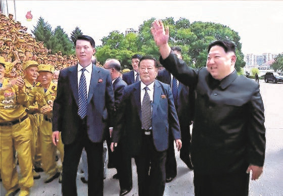 图为上个月28日举行的第八届全国老兵大会上朝鲜警卫员贴身保护国务委员长金正恩(右)。【照片来源：朝鲜中央电视台=韩联社】